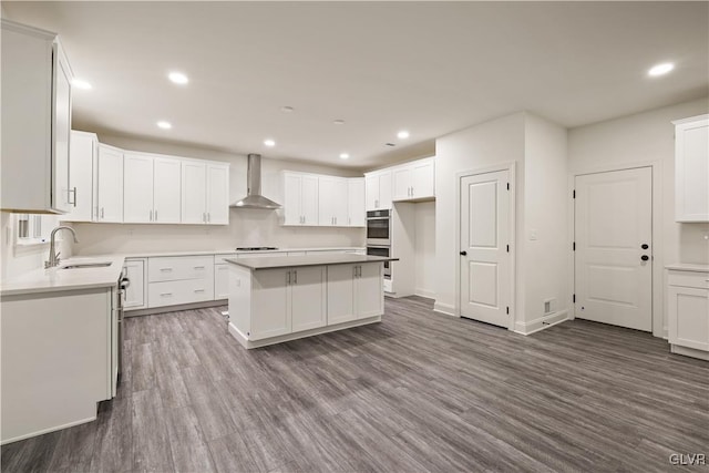 kitchen with wall chimney range hood and white cabinets