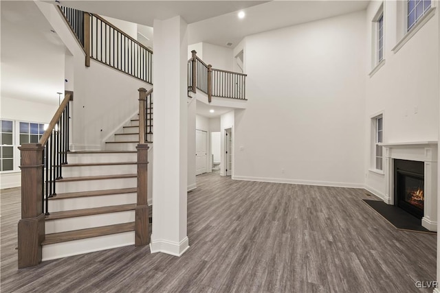 unfurnished living room with a high ceiling and dark hardwood / wood-style floors