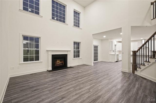 unfurnished living room featuring dark wood-type flooring and sink