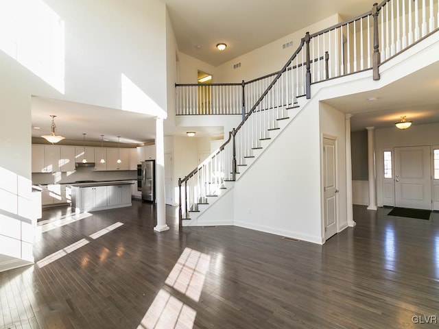 foyer featuring ornate columns, a high ceiling, and dark hardwood / wood-style floors