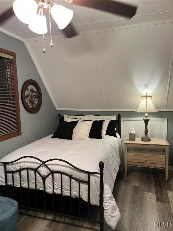 bedroom featuring lofted ceiling, ceiling fan, dark hardwood / wood-style flooring, and ornamental molding