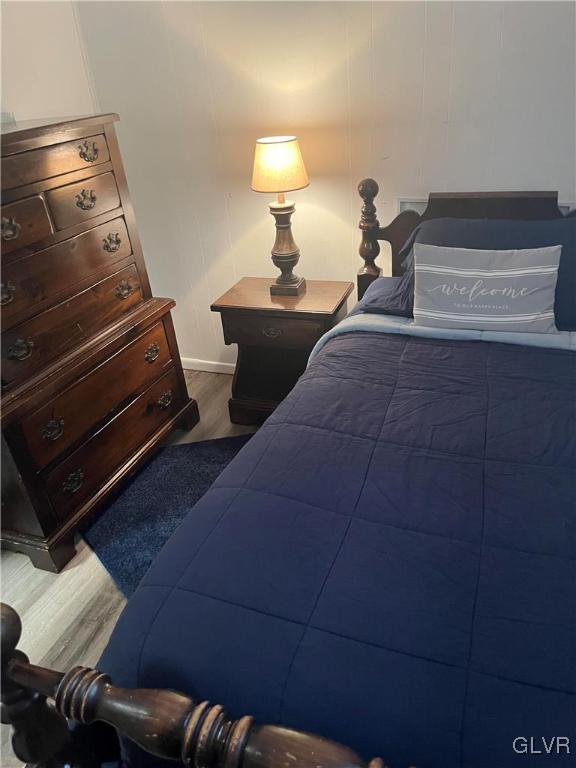 bedroom with dark hardwood / wood-style flooring