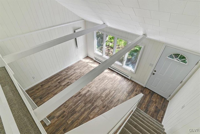 foyer entrance featuring dark hardwood / wood-style floors, vaulted ceiling, a baseboard radiator, and wood walls