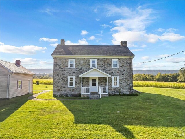 rear view of property with a lawn