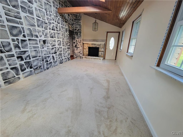 unfurnished living room with carpet flooring, a healthy amount of sunlight, wooden ceiling, and a fireplace