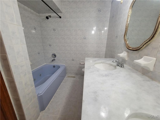 full bathroom featuring vanity, tile walls, tiled shower / bath combo, and toilet