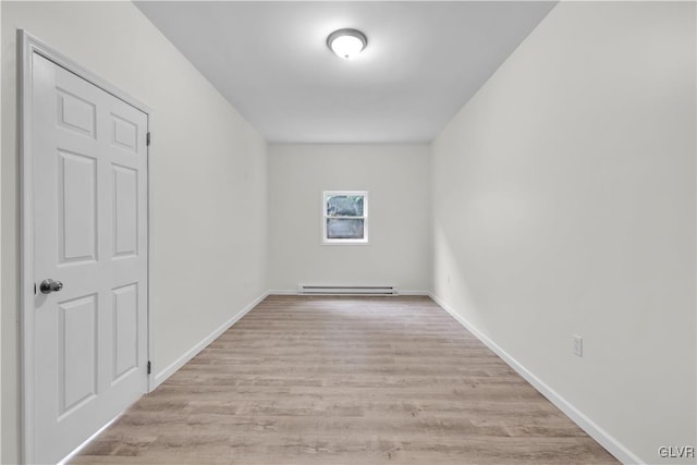 spare room with a baseboard radiator and light wood-type flooring