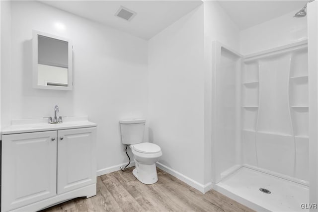 bathroom with vanity, toilet, hardwood / wood-style floors, and walk in shower