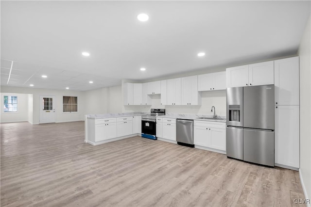 kitchen featuring light wood-type flooring, white cabinetry, stainless steel appliances, and sink