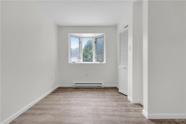 unfurnished bedroom with light wood-type flooring and baseboard heating