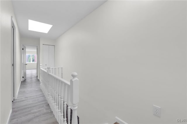 hall featuring a skylight and light hardwood / wood-style floors