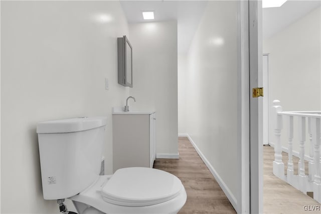 bathroom with vanity, toilet, and hardwood / wood-style floors