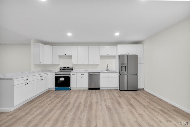 kitchen with appliances with stainless steel finishes, light hardwood / wood-style floors, kitchen peninsula, sink, and white cabinetry