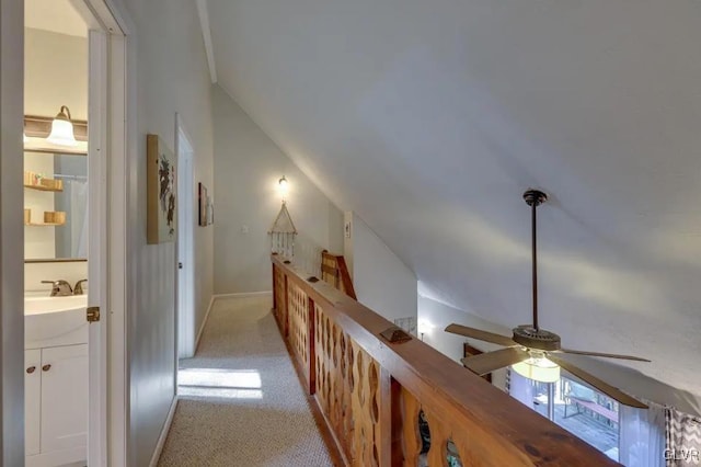 hall featuring light colored carpet and a sink