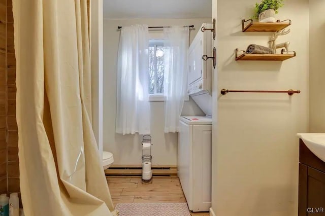 full bathroom with a baseboard heating unit, toilet, wood finished floors, and vanity