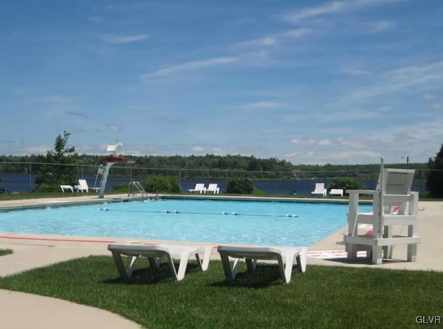 community pool featuring a patio, fence, and a lawn