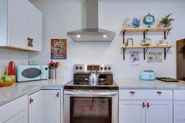 kitchen featuring white cabinetry, ventilation hood, stainless steel range with electric cooktop, light stone countertops, and white microwave