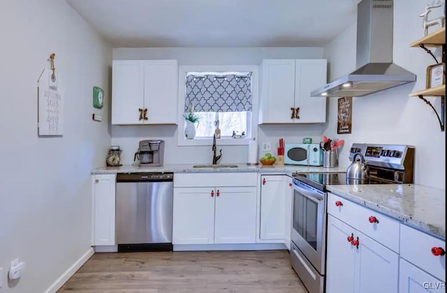 kitchen featuring a sink, extractor fan, white cabinetry, and stainless steel appliances