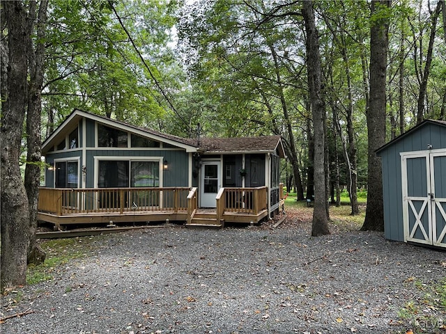 view of front of home with a storage unit, an outbuilding, and a deck