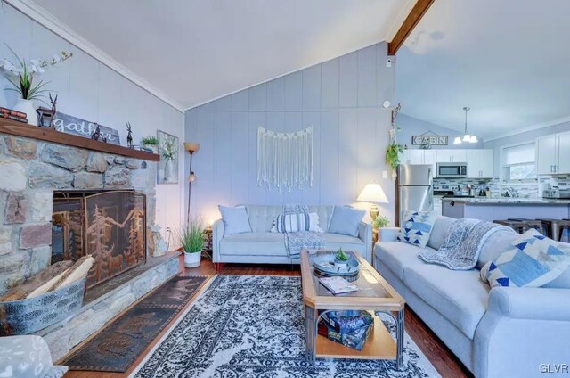 living room with a fireplace, dark hardwood / wood-style floors, lofted ceiling with beams, and ornamental molding