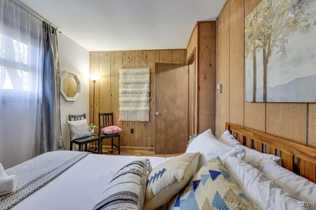 bedroom featuring wood walls and hardwood / wood-style floors