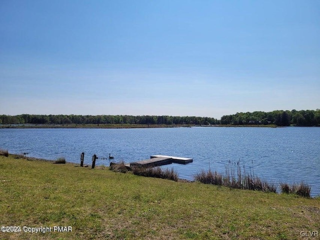 view of dock with a water view and a lawn