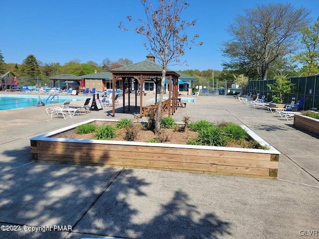 view of property's community featuring a gazebo, a pool, and a patio