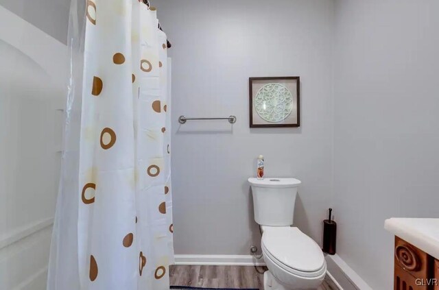 bathroom with a shower with shower curtain, vanity, toilet, and wood-type flooring