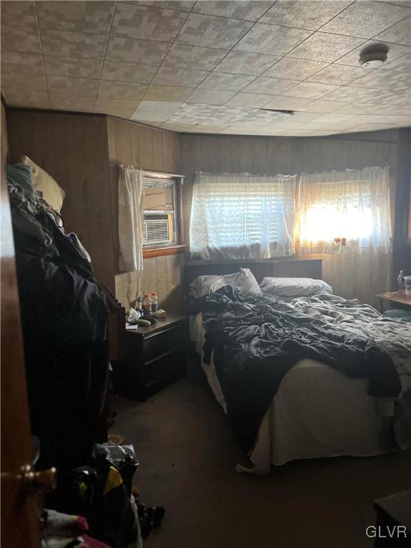 bedroom with cooling unit and wooden walls