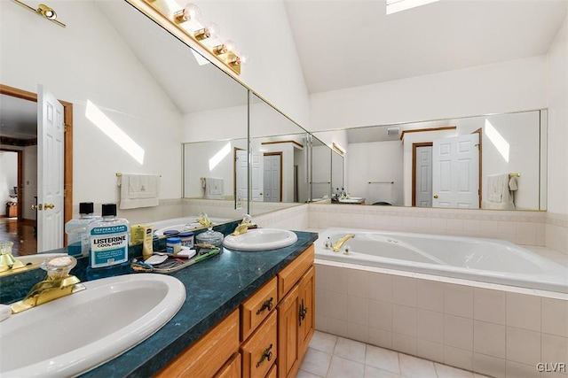 bathroom featuring tiled tub, vanity, lofted ceiling with skylight, and tile patterned floors