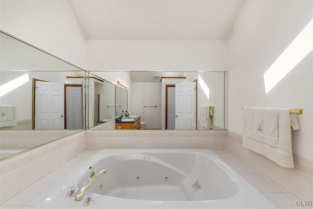 bathroom with tiled bath and vanity