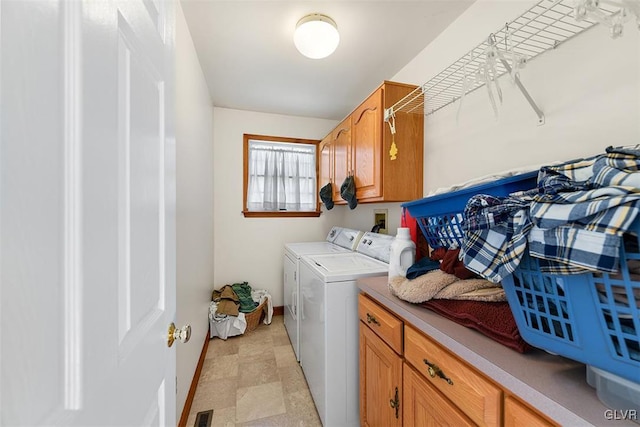 laundry area with washing machine and dryer and cabinets