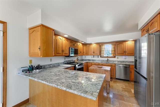 kitchen featuring plenty of natural light, kitchen peninsula, sink, and appliances with stainless steel finishes