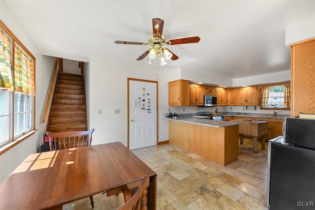 kitchen with stainless steel appliances, kitchen peninsula, and ceiling fan