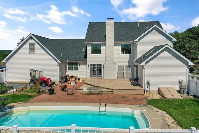 back of house with a fenced in pool and a patio