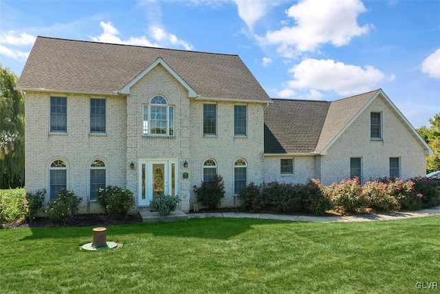 colonial-style house featuring a front yard