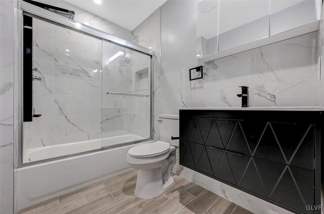 full bathroom featuring enclosed tub / shower combo, toilet, and sink