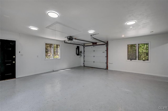 garage with a garage door opener and electric panel