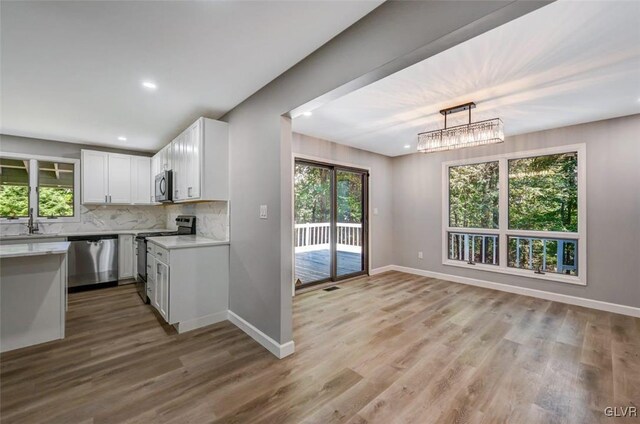 kitchen featuring white cabinets, appliances with stainless steel finishes, and a wealth of natural light