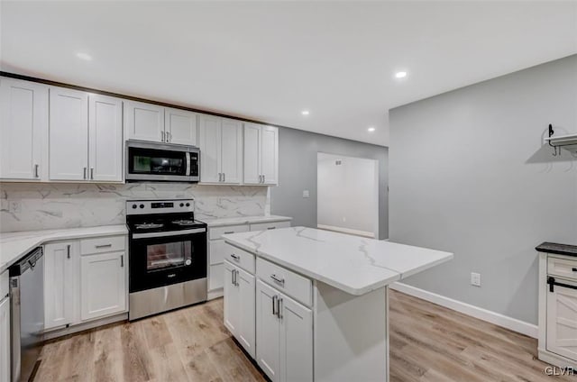 kitchen featuring a kitchen island, stainless steel appliances, decorative backsplash, and light hardwood / wood-style flooring