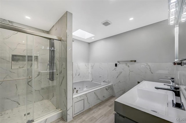 bathroom with plus walk in shower, a skylight, wood-type flooring, and vanity