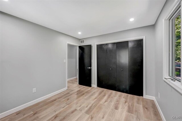 unfurnished bedroom featuring a closet and light hardwood / wood-style floors