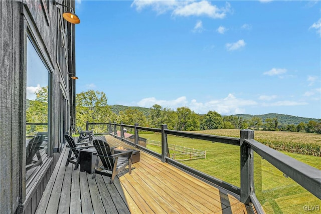 deck with a lawn and a rural view