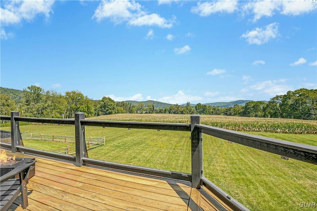 wooden terrace with a lawn and a rural view