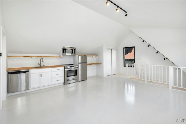 kitchen featuring lofted ceiling, stainless steel appliances, white cabinetry, and sink