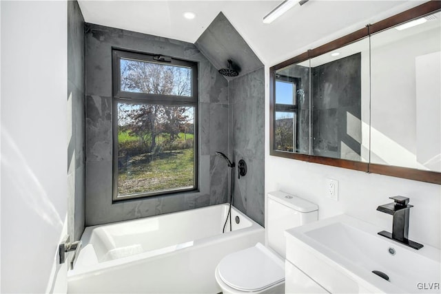 full bathroom featuring vanity, toilet, tiled shower / bath combo, and a healthy amount of sunlight