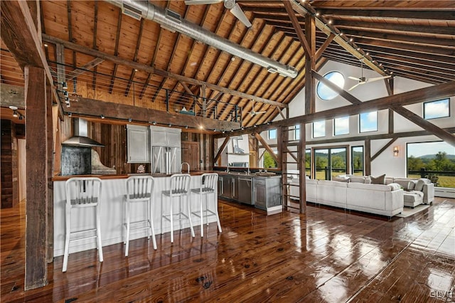 kitchen featuring wall chimney exhaust hood, beamed ceiling, high vaulted ceiling, and dark hardwood / wood-style floors