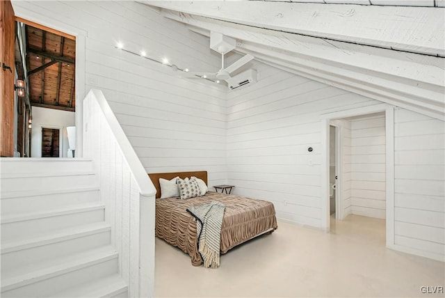 bedroom featuring vaulted ceiling, an AC wall unit, wooden walls, and concrete flooring