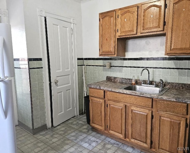 kitchen with tile walls, white refrigerator, tasteful backsplash, and sink