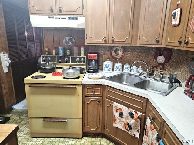 kitchen with sink, electric range, and tasteful backsplash